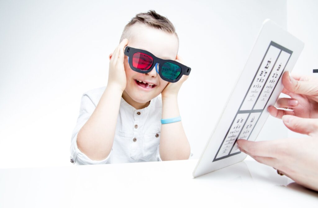A child cheerfully adjusts their specialty eyeglasses during vision therapy.