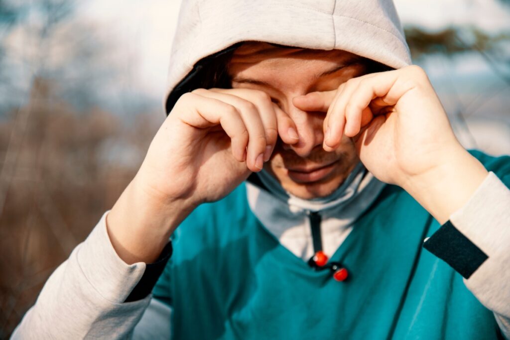 Man with dry eyes running outside.
